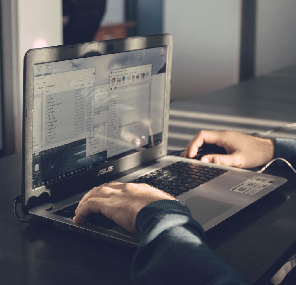 Técnico trabajando en laptop con administración de sistemas y soporte TI
